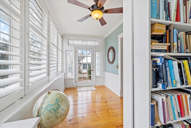 entrance foyer featuring crown molding, ceiling fan, and light hardwood / wood-style flooring