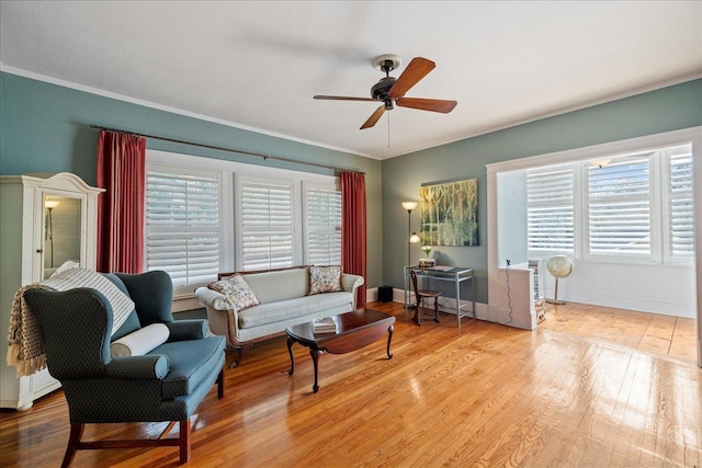 living room featuring crown molding, light hardwood / wood-style floors, and ceiling fan