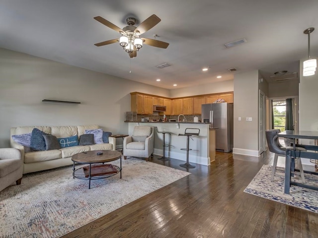 living room with ceiling fan and dark hardwood / wood-style floors