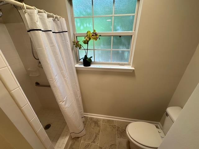 5356 Tewkesbury Trce, Tallahassee, FL 32309 - full bath with a stall shower, toilet, healthy amount of natural light, and baseboards