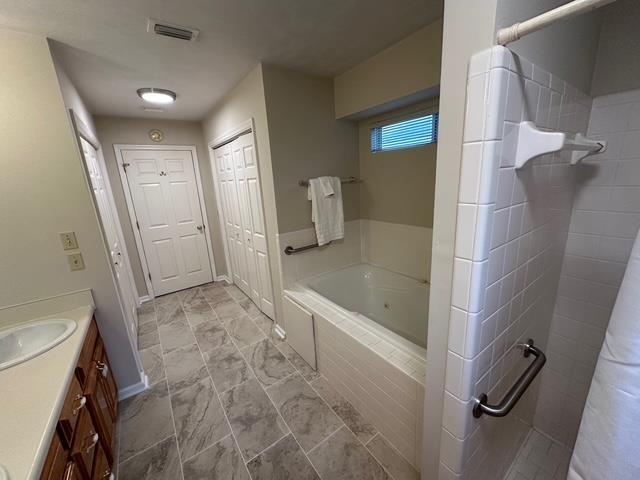 5356 Tewkesbury Trce, Tallahassee, FL 32309 - bathroom with a whirlpool tub, vanity, a tile shower, and marble look tiles