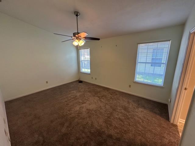 5356 Tewkesbury Trce, Tallahassee, FL 32309 - spare room featuring dark carpet, baseboards, and a ceiling fan