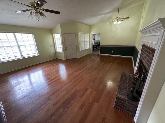 5356 Tewkesbury Trce, Tallahassee, FL 32309 - unfurnished living room with ceiling fan, lofted ceiling, a brick fireplace, wood finished floors, and baseboards