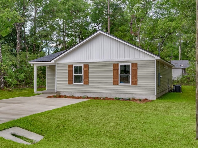 view of side of property featuring a yard and central AC unit