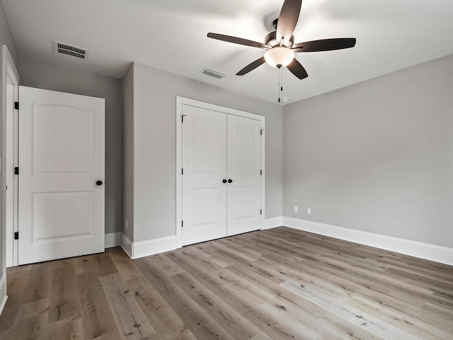 unfurnished bedroom with ceiling fan, light hardwood / wood-style floors, and a closet