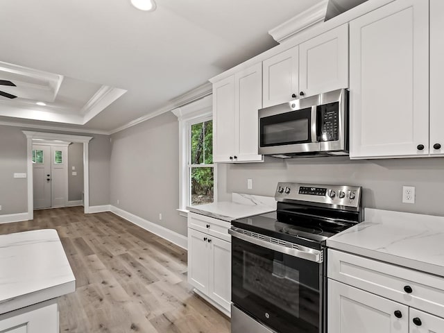 kitchen featuring crown molding, white cabinets, stainless steel appliances, and light wood-type flooring