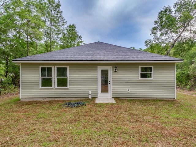 rear view of property featuring a yard