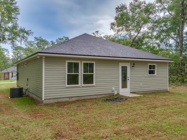 rear view of house featuring a yard and cooling unit