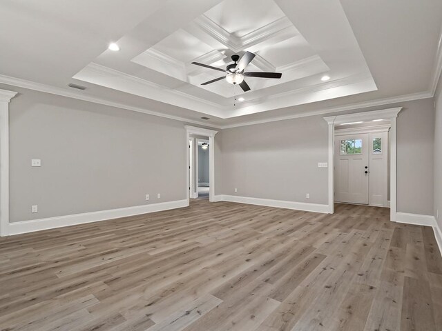 interior space featuring decorative columns, ornamental molding, a tray ceiling, ceiling fan, and light hardwood / wood-style flooring