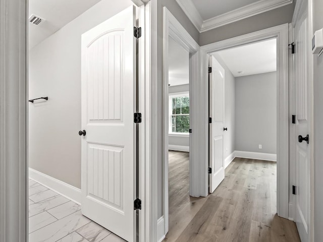 corridor with light wood-type flooring and crown molding