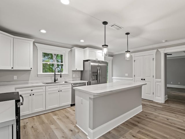 kitchen with white cabinets, crown molding, sink, light hardwood / wood-style floors, and stainless steel appliances