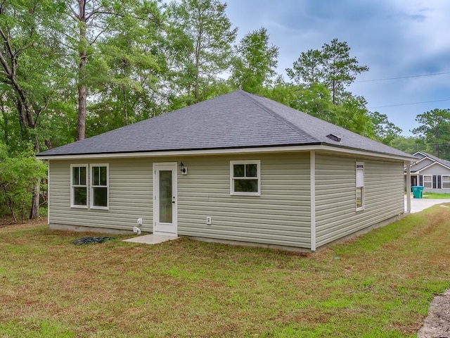 rear view of property featuring a lawn