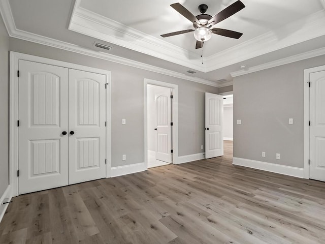 unfurnished bedroom featuring ceiling fan, light wood-type flooring, and crown molding