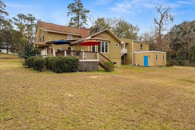 rear view of house with a lawn and a wooden deck