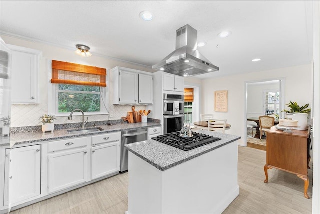 kitchen with island range hood, a kitchen island, white cabinets, and appliances with stainless steel finishes