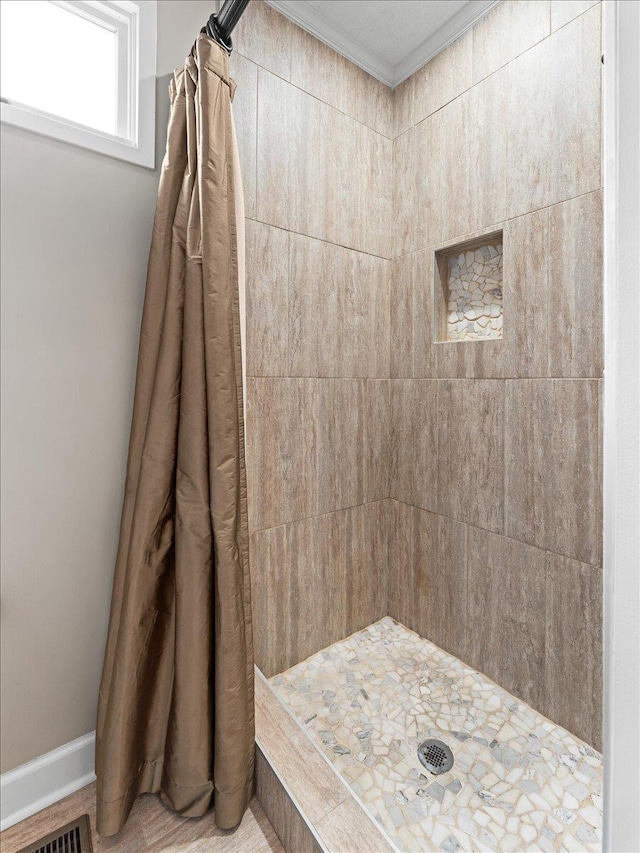 bathroom featuring crown molding and walk in shower