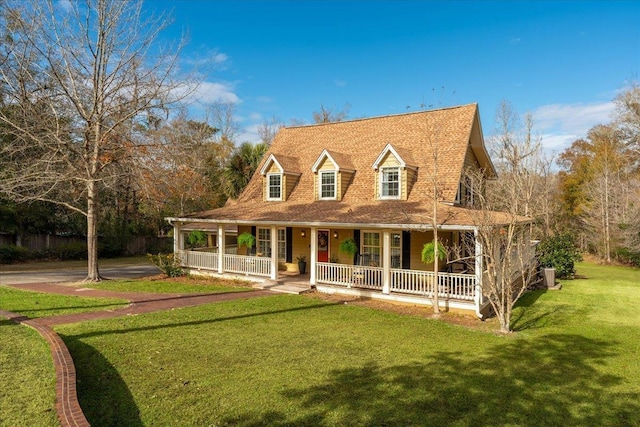 view of front of home featuring a front yard, a porch, and central AC