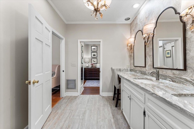 bathroom with vanity, a textured ceiling, crown molding, an inviting chandelier, and hardwood / wood-style floors