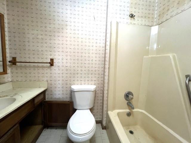 bathroom with toilet, bathing tub / shower combination, tile patterned flooring, and vanity