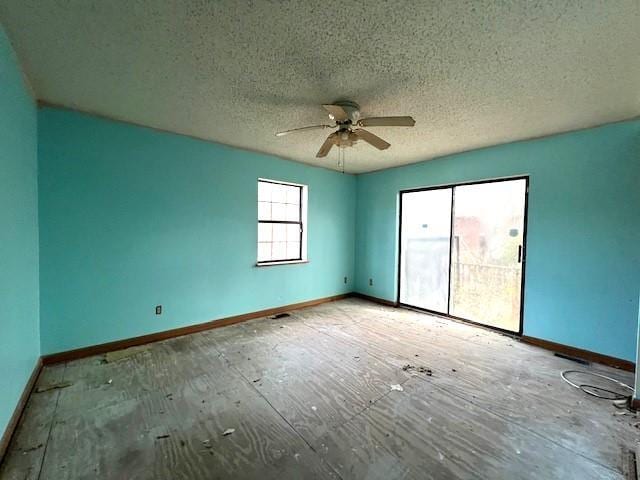 unfurnished room featuring ceiling fan, a textured ceiling, and baseboards