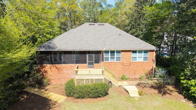 view of front of house featuring a sunroom and brick siding