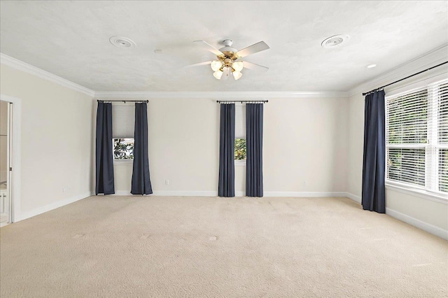 empty room featuring baseboards, ornamental molding, carpet, and a ceiling fan