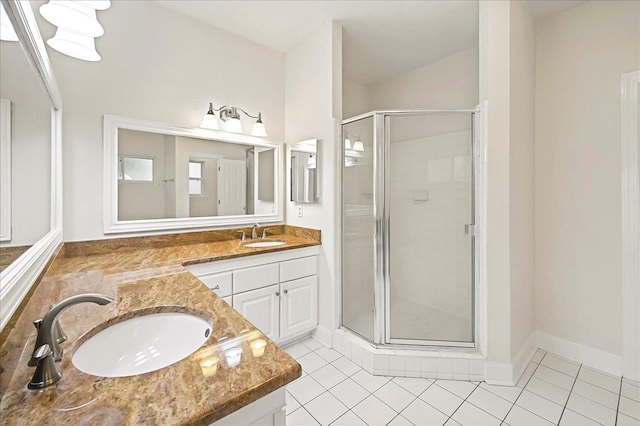 full bath featuring a shower stall, tile patterned floors, baseboards, and vanity