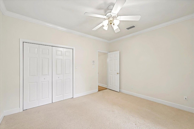 unfurnished bedroom with baseboards, carpet flooring, ornamental molding, and visible vents