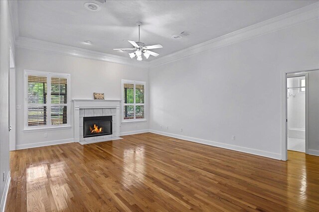 unfurnished living room featuring a wealth of natural light, crown molding, and ceiling fan