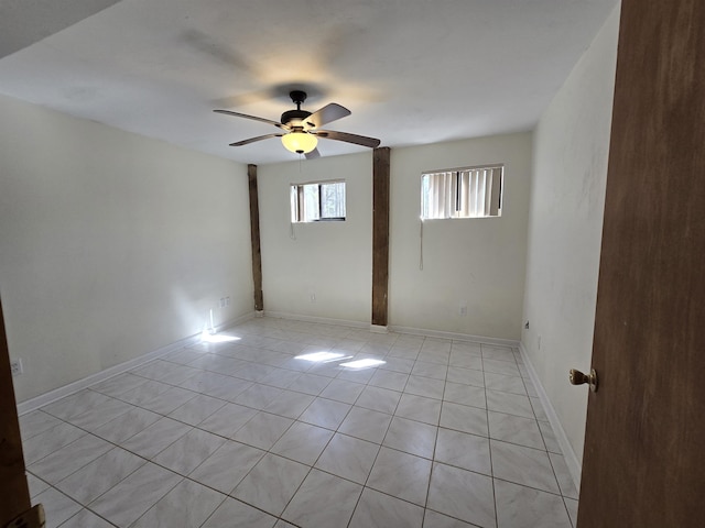 spare room featuring light tile patterned flooring, baseboards, and a ceiling fan