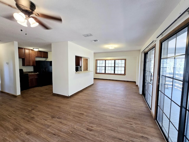 kitchen with visible vents, dark wood-type flooring, baseboards, black appliances, and a ceiling fan