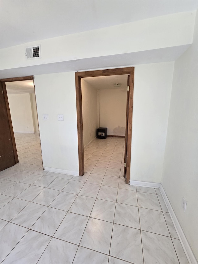 interior space featuring light tile patterned floors, visible vents, and baseboards