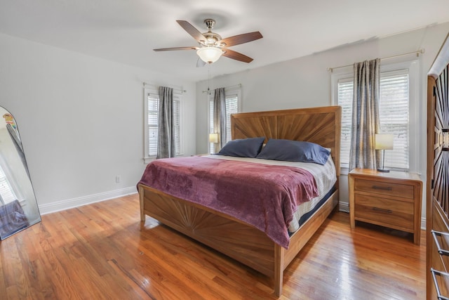 bedroom with baseboards, a ceiling fan, and light wood-style floors