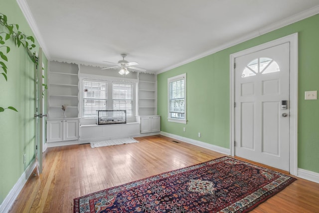 entrance foyer featuring baseboards, ornamental molding, ceiling fan, and hardwood / wood-style flooring