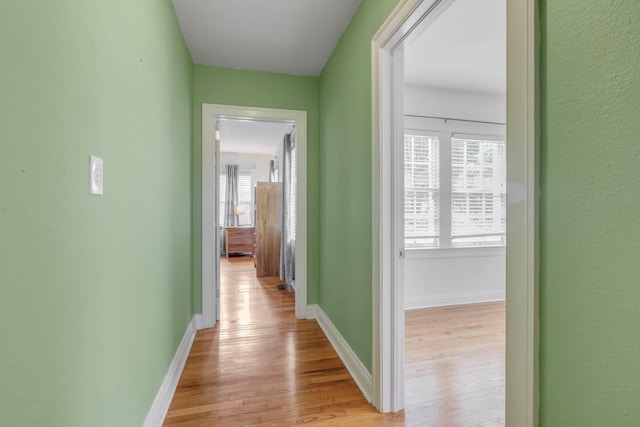 hall featuring baseboards and light wood-style flooring