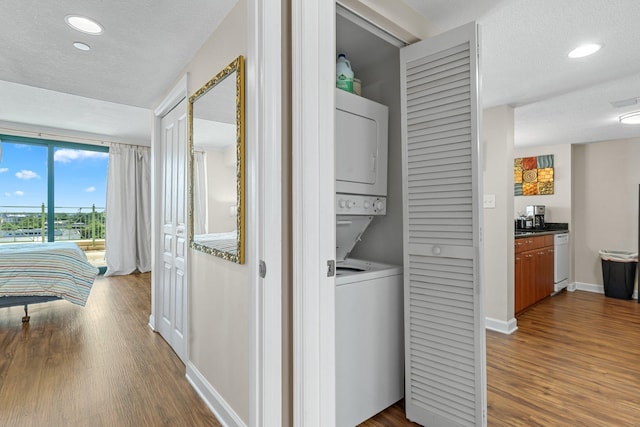 300 S Duval St Unit 503, Tallahassee, FL 32301 - washroom featuring estacked washer and dryer, dark wood-type flooring, baseboards, recessed lighting, and a textured ceiling