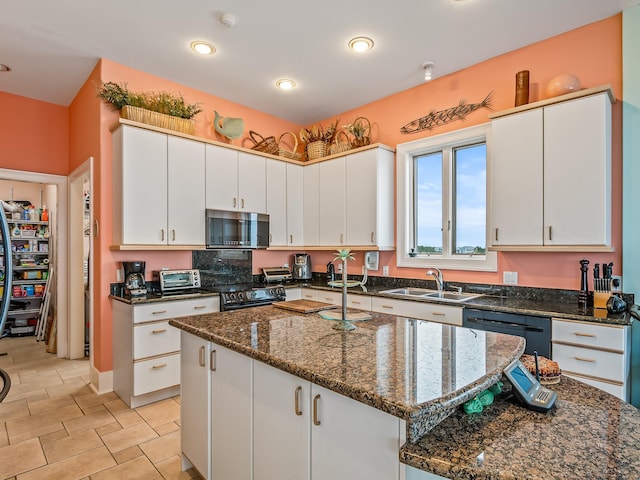 kitchen featuring white cabinetry, sink, and a kitchen island