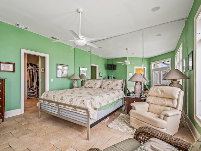 bedroom with ceiling fan, a walk in closet, and a closet