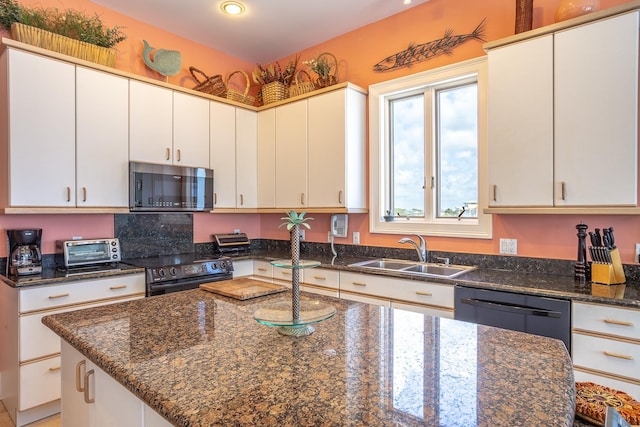 kitchen with black electric range oven, dark stone counters, sink, dishwasher, and white cabinetry