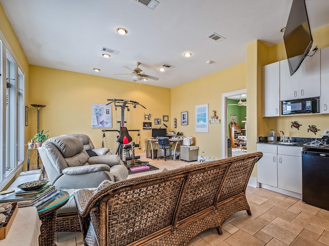 living room with light tile patterned floors, ceiling fan, and sink