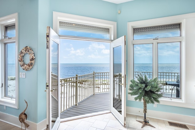 doorway to outside with light tile patterned flooring and a water view