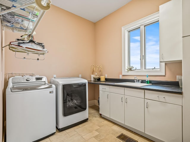 laundry room featuring cabinets, washer and clothes dryer, and sink