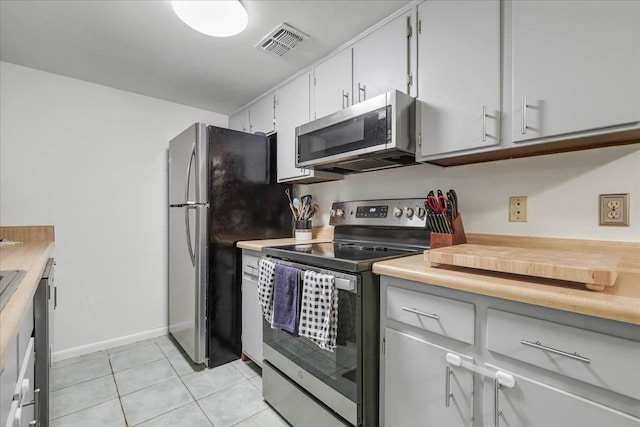 1520 Pullen Rd Unit 6, Tallahassee, FL 32303 - kitchen featuring stainless steel appliances, light countertops, light tile patterned floors, baseboards, and white cabinetry