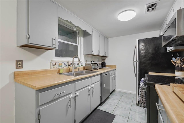 1520 Pullen Rd Unit 6, Tallahassee, FL 32303 - kitchen featuring appliances with stainless steel finishes, a sink, light countertops, light tile patterned floors, and baseboards
