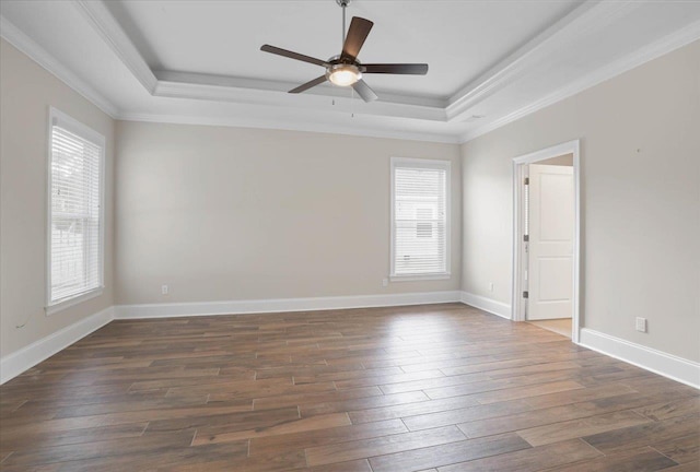 spare room featuring dark hardwood / wood-style flooring, a raised ceiling, ceiling fan, and crown molding