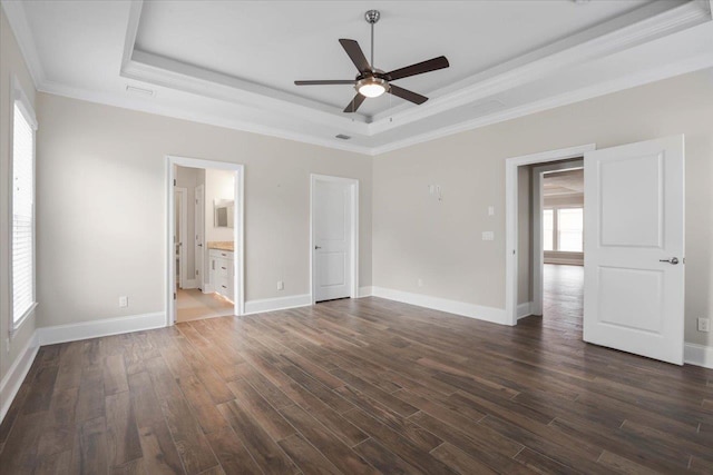 unfurnished bedroom with ensuite bathroom, ceiling fan, a raised ceiling, and dark hardwood / wood-style floors