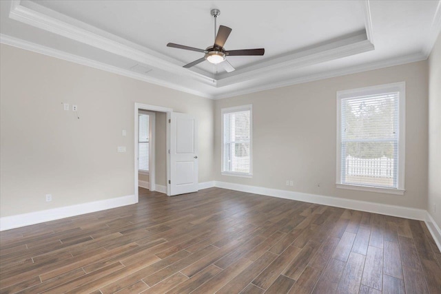 unfurnished room with dark hardwood / wood-style flooring, a tray ceiling, and plenty of natural light