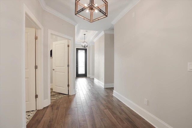 corridor featuring dark hardwood / wood-style floors, crown molding, and a notable chandelier