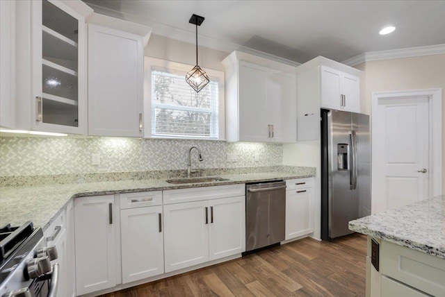 kitchen featuring sink, stainless steel appliances, tasteful backsplash, pendant lighting, and white cabinets