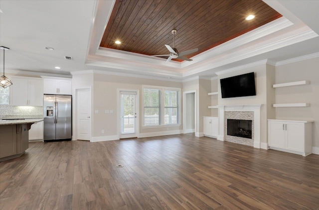 unfurnished living room with a raised ceiling, crown molding, ceiling fan, wood ceiling, and a tiled fireplace